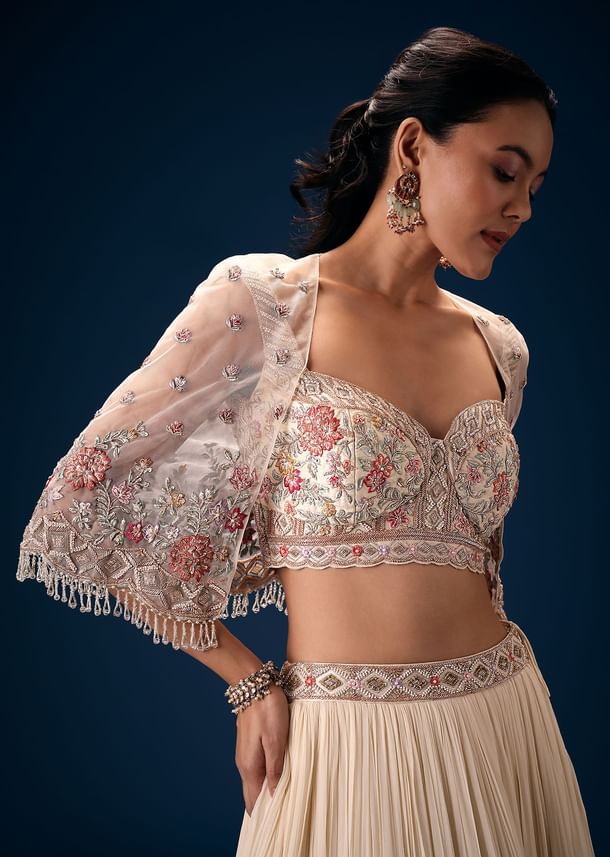 Off White Tiered Lehenga With Embroidered Corset Blouse And Embroidered Cape