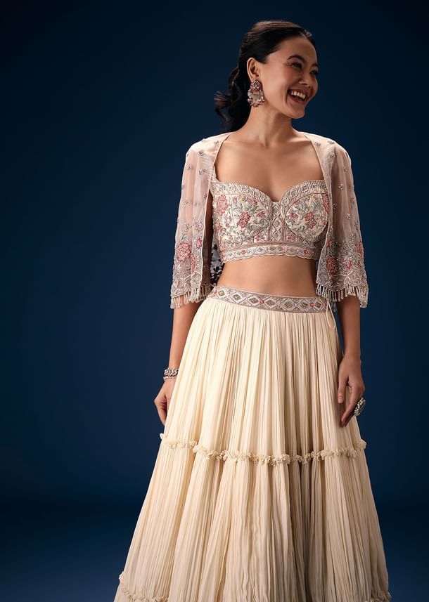 Off White Tiered Lehenga With Embroidered Corset Blouse And Embroidered Cape