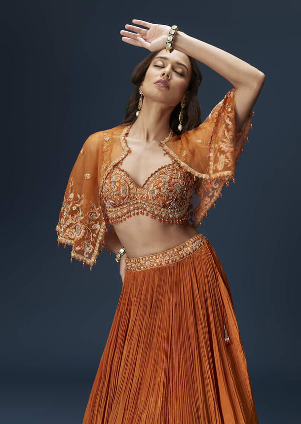 Rust Orange Embroidered Lehenga With Dramatic Cape And Blouse Rust Orange Embroidered Lehenga With Dramatic Cape And Blouse